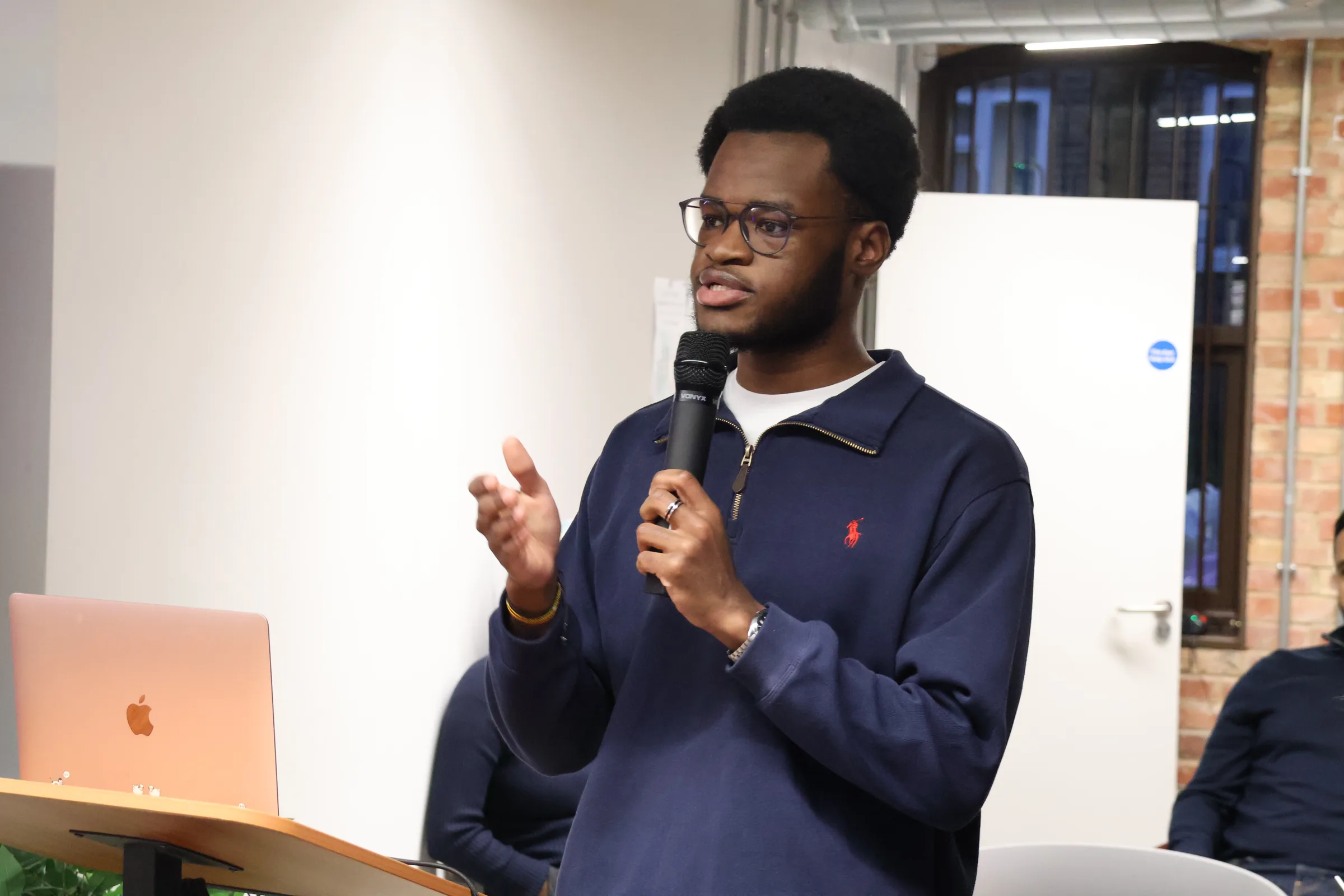 Sipho Yawe mid-talk, gesturing to the room